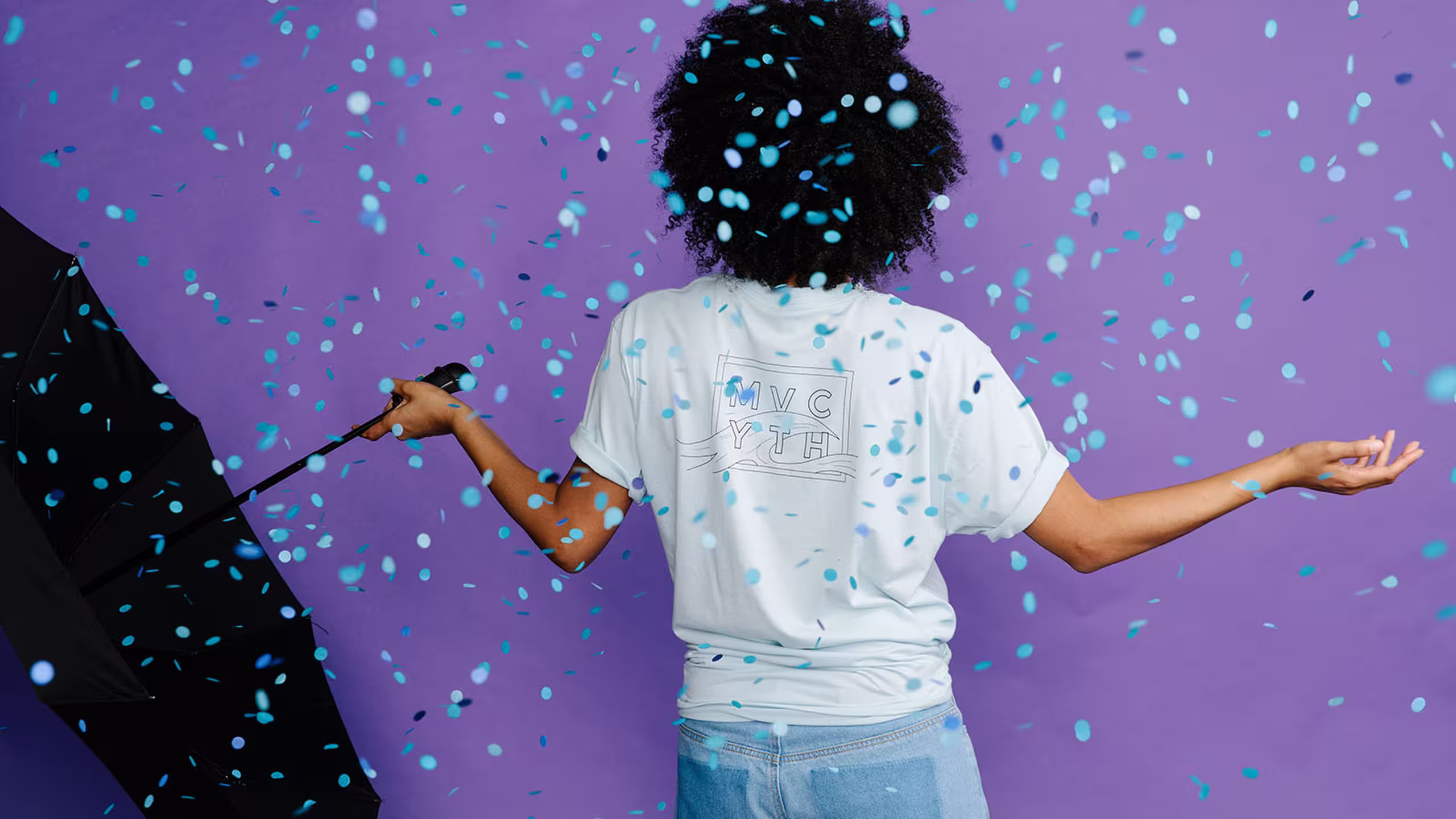 women with an umbrella in front of a purple background with blue confetti falling