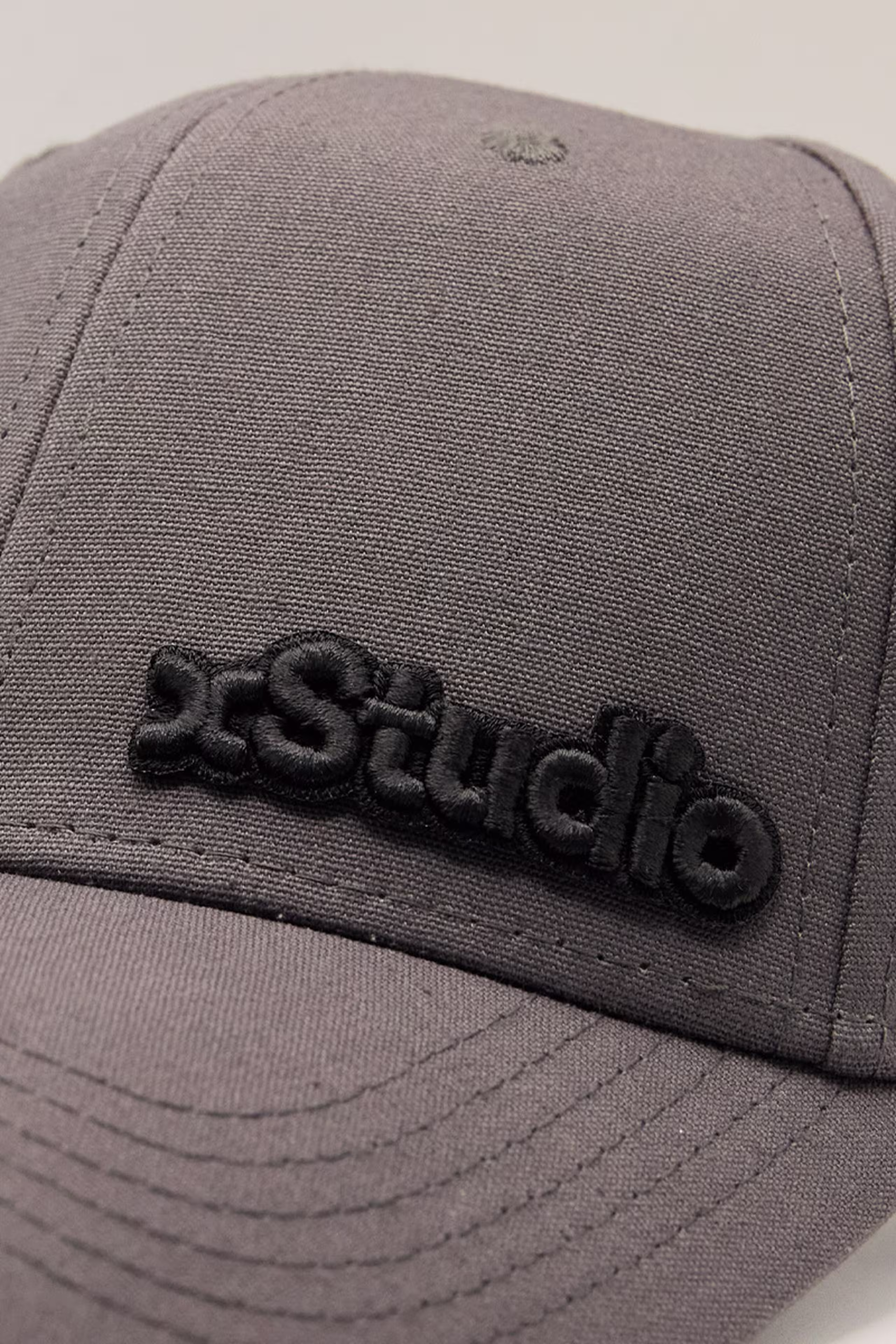 close-up of a black 3d embroidery patch on a grey hat